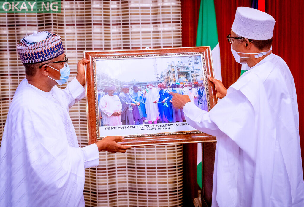President of Dangote Group, Aliko Dangote, and President Muhammadu Buhari, admiring a picture taken during the commissioning of Dangote Fertilizer in Lagos recently, during a courtesy visit by the Management and Board of Dangote Industries Limited (DIL), to the Presidential Villa, in Abuja on Friday