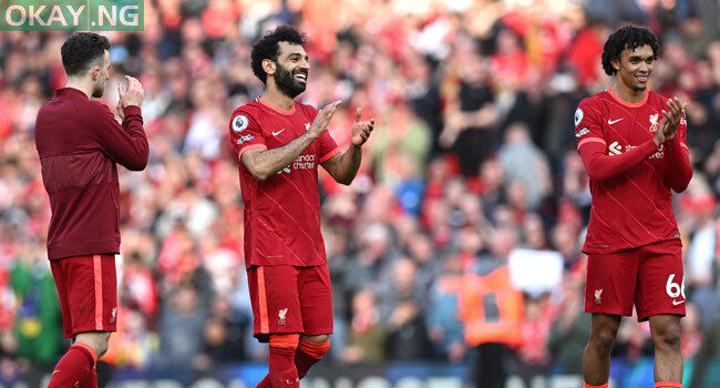 Liverpool’s Portuguese striker Diogo Jota (L), Liverpool’s Egyptian midfielder Mohamed Salah (C) and Liverpool’s English defender Trent Alexander-Arnold applauds the fans following the English Premier League football match between Liverpool and Everton at Anfield in Liverpool, north west England on April 24, 2022. Liverpool won the match 2-0. Paul ELLIS / AFP