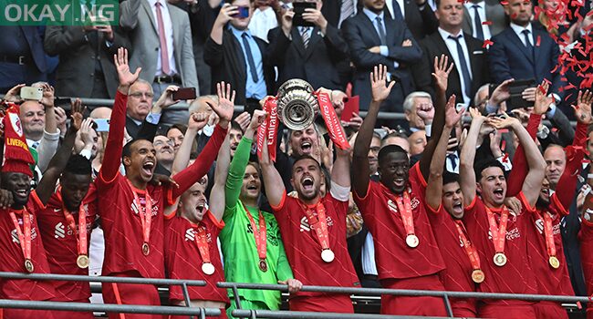 Liverpool’s English midfielder Jordan Henderson lifts the trophy as Liverpool players celebrate after winning the English FA Cup final football match between Chelsea and Liverpool, at Wembley stadium, in London, on May 14, 2022.