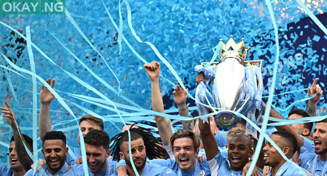 Manchester City’s Brazilian midfielder Fernandinho lifts the Premier League trophy as City players celebrate on the pitch after the English Premier League football match between Manchester City and Aston Villa at the Etihad Stadium in Manchester, north west England, on May 22, 2022. Oli SCARFF / AFP